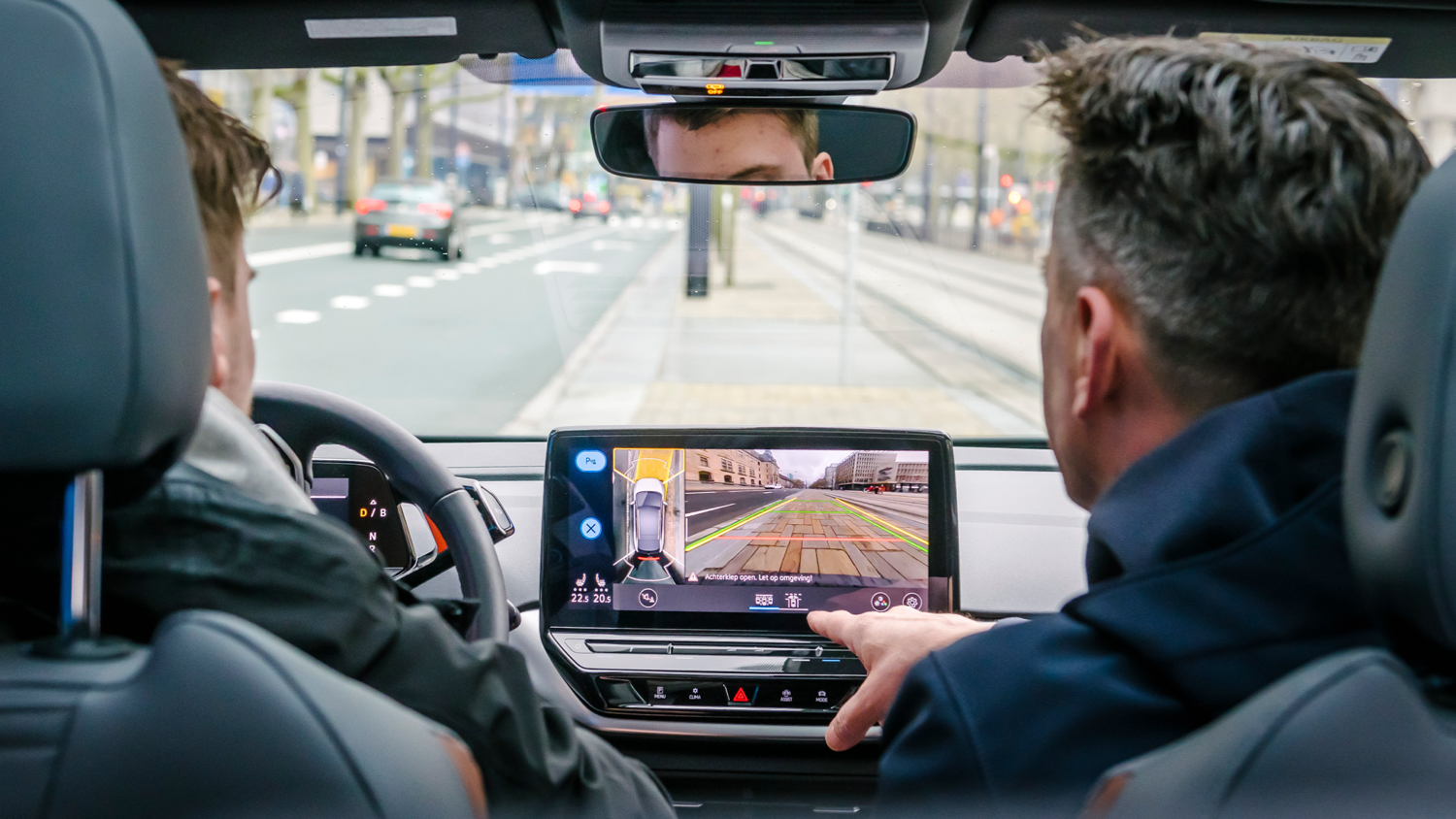 Twee mensen in de cockpit van een ID.3 tijdens het inparkeren